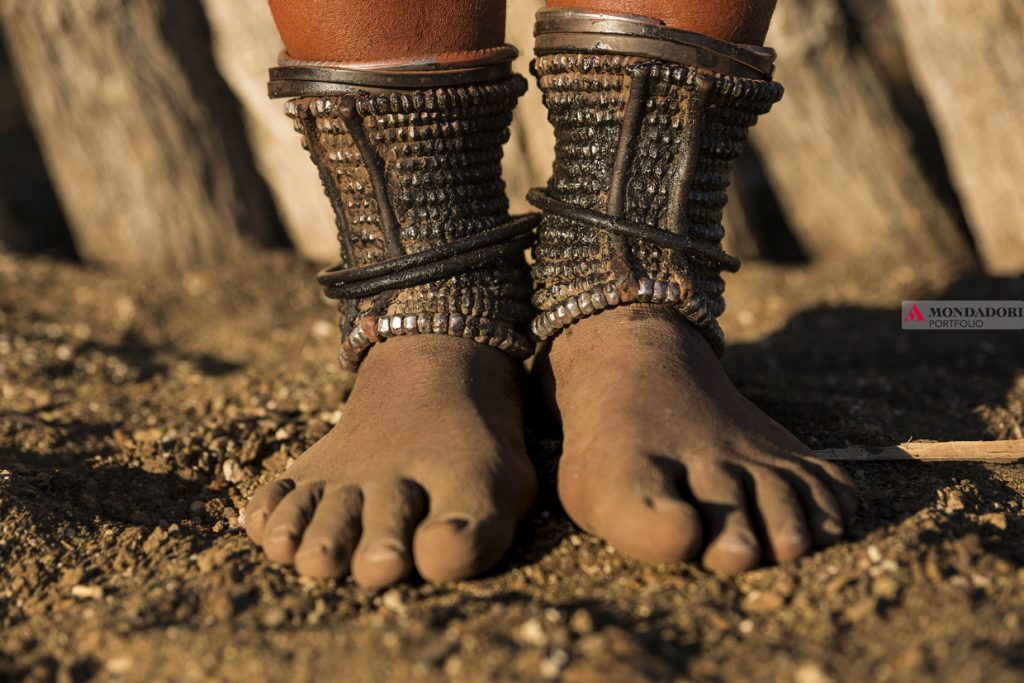 Angola - Le donne Himba, nella regione di Kunene, indossano cavigliere decorate (Omohanga) che permettono loro di nascondere il denaro e le proteggono dai morsi di animali velenosi.