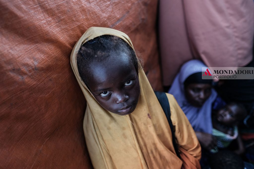 Una ragazzina somala in un campo a Mogadiscio per sfollati interni (IDS camp) allestito dalle Nazioni Unite. In Somalia ci sono oltre 2 milioni e mezzo di sfollati interni, che hanno dovuto lasciare i loro villaggi a causa di guerre o carestie. A queste se ne sono aggiunte oltre 200,000 solo nei primi mesi del 2018.