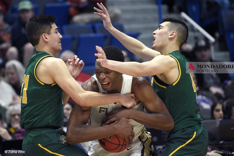 È iniziata la March Madness, la fase finale del campionato di basket di college NCAA. Nella foto il giocatore di Florida State, Seminoles Mfiondu Kabengele cerca di trovare spazio tra le guardie dei Vermont Catamounts Everett Duncan e Robin Duncan. 