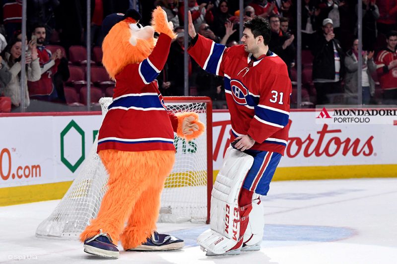 La mascotte dei Montreal Canadiens Youppi dà un cinque al giocatore Carey Price dopo la partita contro i Detroit Red Wings.