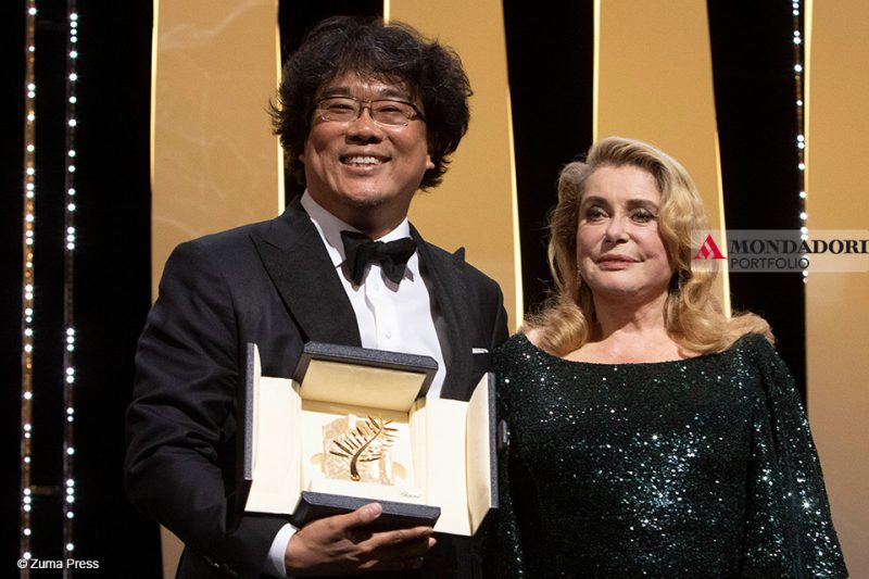 Il regista sudcoreano Bong Joon-Ho insieme a Catherine Deneuve, che gli consegna la Palma d'Oro al Festival di Cannes.